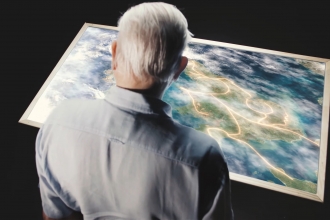 Sir David Attenborough looking at a map
