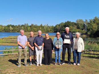 A group of volunteers from the Friends of Bottesford Beck, holding the Lincolnshire Environmental Awards trophy