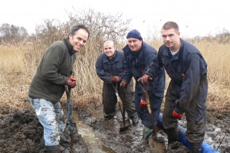 A group of friends dig in the mud