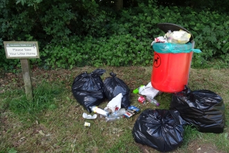 Litter next to a sign asking people to take their litter home