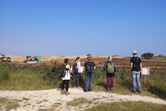 Group of people watching turf stripping on the Lincolnshire coast