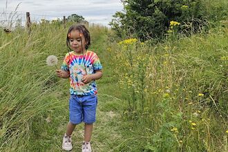 Child holding a dandelion