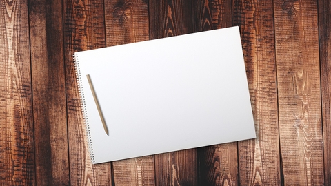 Notepad and pencil on a wooden background