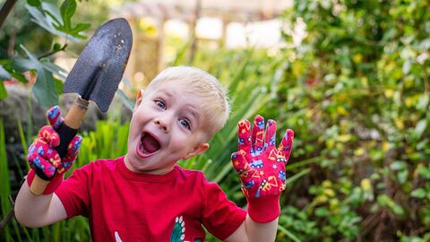 boy in a garden with a tool