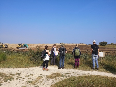 Group of people watching turf stripping on the Lincolnshire coast