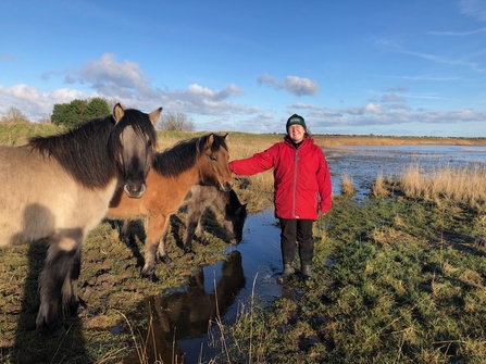 Residential volunteer, Emma Fowler, standing next to ponies