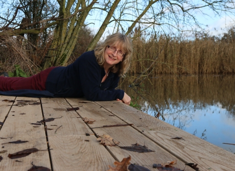 Nicky sits on the edge of a lake