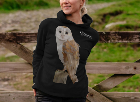 Woman in the countryside wearing a Lincolnshire Wildlife Trust barn owl design hoodie