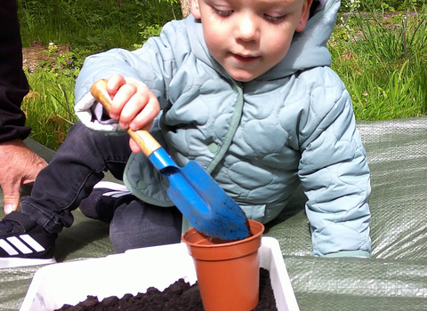 Young child planting at Nature Tots session at Gibraltar Point